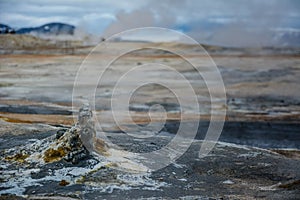 Cone in Hverir geothermal area with boiling mudpools and steaming fumaroles in Iceland in summer.  Myvatn region, North part of