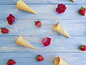 Cone wafflefor ice cream, strawberry, refreshment pattern creative rose flower pattern on a blue wooden