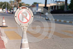 Cone warning about a parking ban of automobile and cars. traffic safety sign on city street road. danger warning symbol on urban w