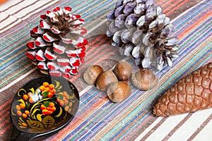 Cones, acorns, ukrainian style wooden spoon on tablecloth, eco kitchen