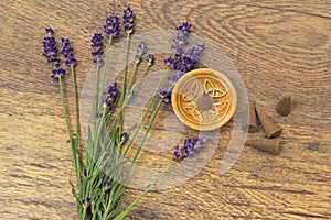 Cones incense and violet lavender flowers on a wooden table