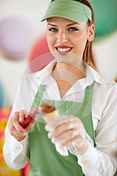 Confectioner in confectionery shop putting ball of ice cream in