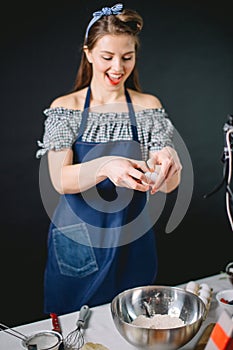 Confectioner cracking an egg into steel dish