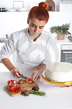 The confectioner decorates cake with fruit