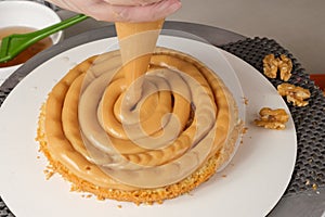 Confectioner finishing the cake filling with dulce de leche brigadeiro photo