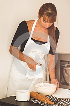 Confectioner girl is preparing a cake. Concept ingredients for cooking flour products or dessert