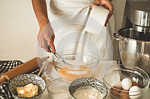 Confectioner girl is preparing a cake. Concept ingredients for cooking flour products or dessert