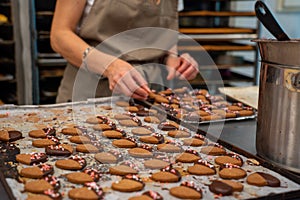 Confectioner making cookies, tea pastes, dipped in chocolate and decorated with sugar hearts