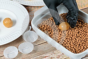 Confectioner placing the brigadeiro brigadier of dulce de leche on salty crunchy caramels photo