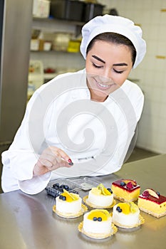 Confectioner preparing cakes at bakery or confectionery