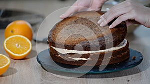 Confectioner puts cream to top of cake. Baker smoothing cake with cream icing.