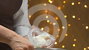 Confectioner puts white cake cream in pastry bag