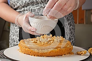 Confectioner putting walnuts in the brigadeiro filling side view photo