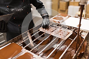 Confectioner removing excess chocolate from mold photo