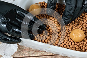 Confectioner rolling a brigadeiro brigadier of dulce de leche with her hands over salty crunchy caramels photo