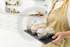 The confectioner's hands are holding school cupcakes