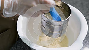 Confectioner sifted through a sieve the ingredients for the preparation of delicious sweets. Professional tools for