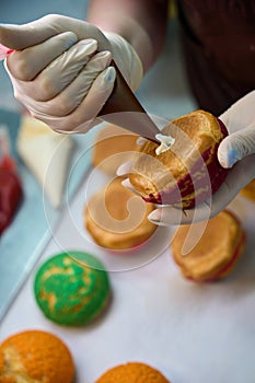 Confectioner squeezing whipped cream into hollow in choux au craquelin photo