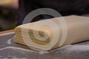 Confectioner works the puff pastry dough, artisan, gourmet photo