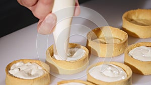 Confectionery creating cupcakes by confectioner syringe. close up photo