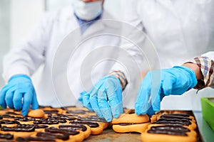 Confectionery factory employees making pastry with chocolate filling