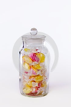 Confectionery. Jar of boiled sweets in wrappers isolated against