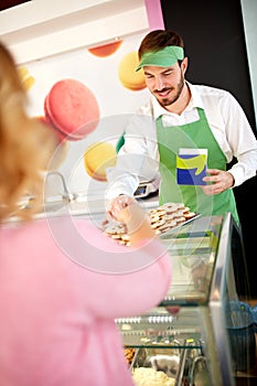 Confectionery salesman showing nice cookies