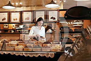 Confectionery. Woman Selling Chocolate Candies In Store
