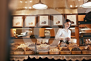 Confectionery. Woman Selling Chocolate Candies In Store