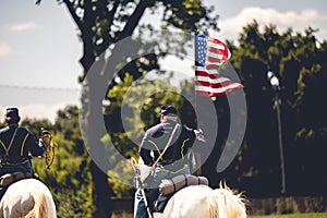 Confederate reenactor riding a horse with a flag of the United States at the Civil War reenactment