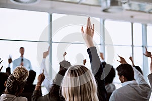 Conference, group and business people with hands for a vote, question or volunteering. Corporate event, meeting and hand