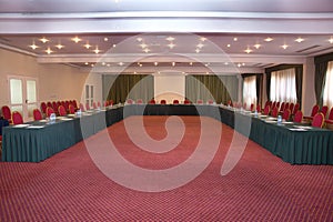 Conference hall at the hotel. Red tables and red carpet . Elegant and rich designed banquet hall. Great file for your new catering