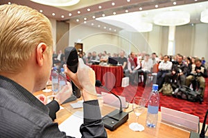 Conference in hall. man with microphone.