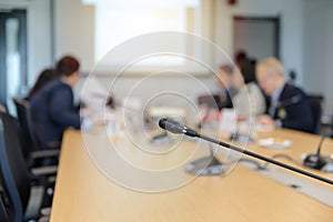 Conference microphones on the table over blurred of attendee in meeting room background