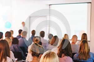 Conference participants listen to the speech and presentation of the speaker in a special audience with a projector and screen.