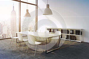 A conference room in a modern panoramic office with New York view. White table, white chairs, a bookcase and two white ceiling lig