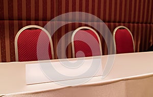 Conference table with red chairs and triangle board in meeting room