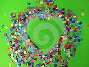 Confetti pattern heart shape on a green background