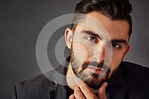 Confidence is attractive. Studio portrait of a handsome young man posing against a dark background.