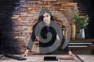 Confidence businesswoman standing in her office with hands on the table