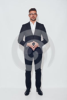 Confidence and success. Full length of handsome businessman in classic wear and eyeglasses looking at camera standing
