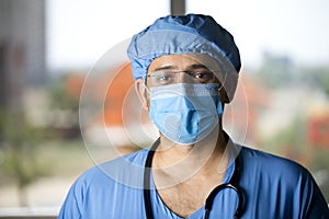 Confidence young male surgeon with face mask looking at camera