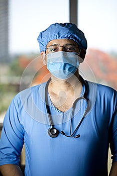 Confidence young male surgeon with face mask looking at camera