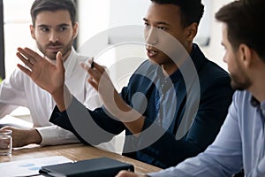 Confident African American businessman speaking at corporate meeting