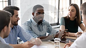 Confident African American businessman wearing glasses speaking at corporate meeting