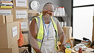 Confident african american woman volunteer, smiling and standing proud at charity center