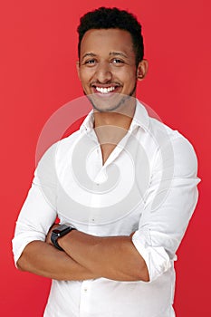 Confident african american young man standing over red background.