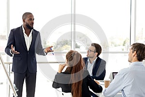 African business coach in suit giving presentation to clients photo