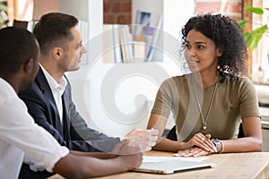 Confident african female applicant talking to diverse hr managers photo