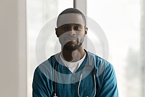 Confident African surgeon man in uniform scrubs posing in clinic